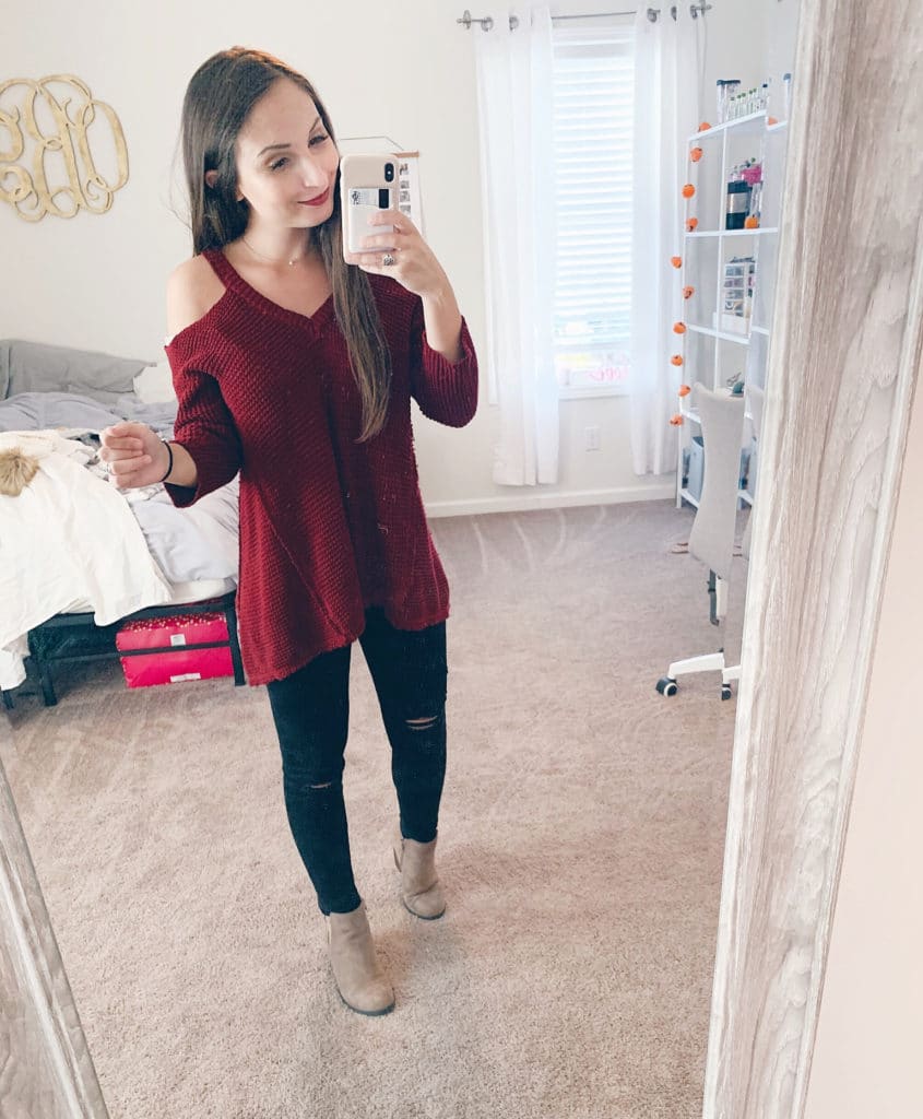 mirror selfie with red cold shoulder sweater and black distressed leggings